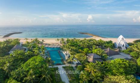 Pemandangan udara resor tepi pantai dengan kolam renang dan pepohonan hijau di Bali