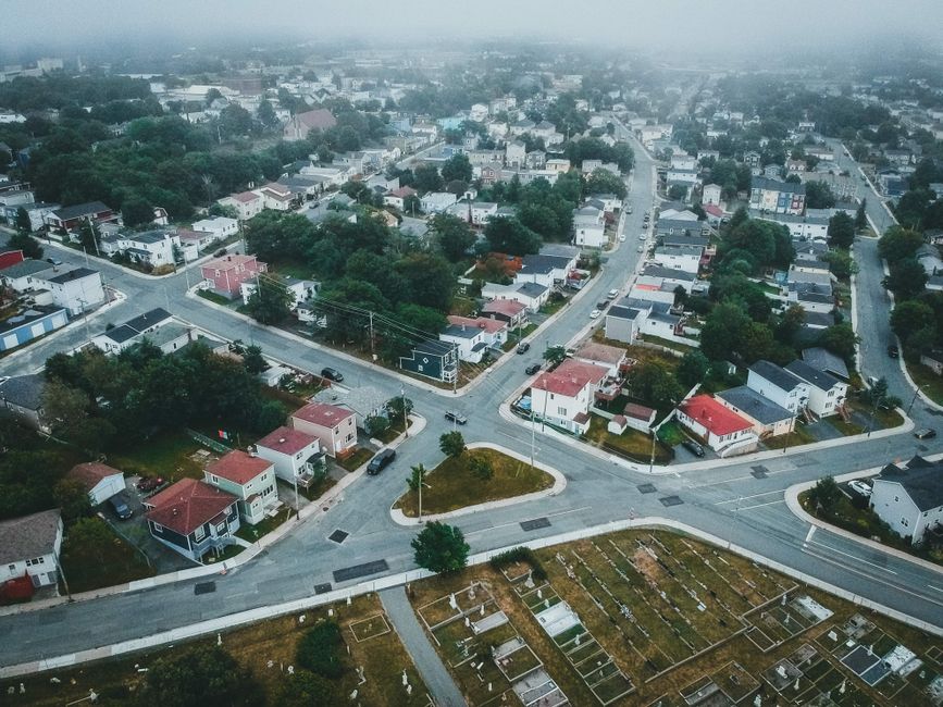 Aerial view capturing a suburban neighborhood with streets and houses under a cloudy sky.