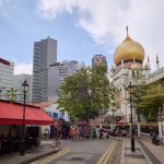 Street view featuring Sultan Mosque and modern skyscrapers in Singapore.