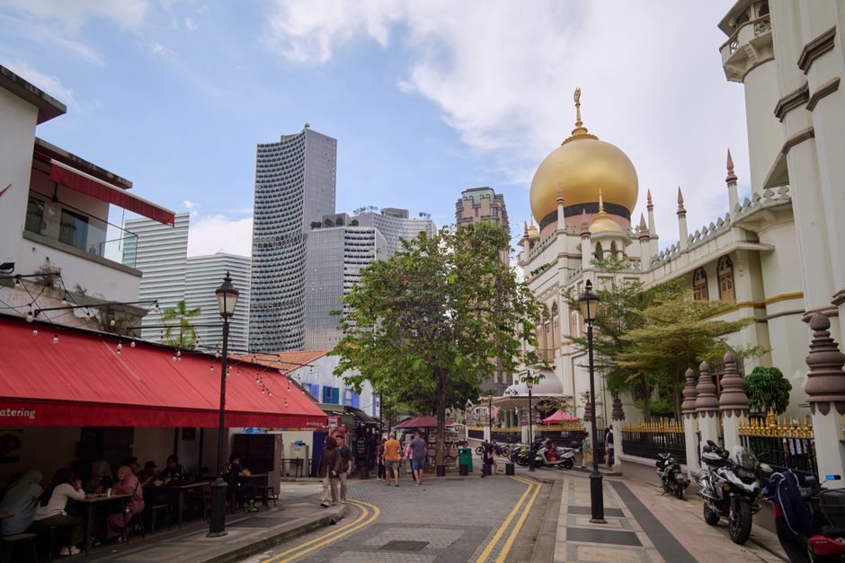 Street view featuring Sultan Mosque and modern skyscrapers in Singapore.
