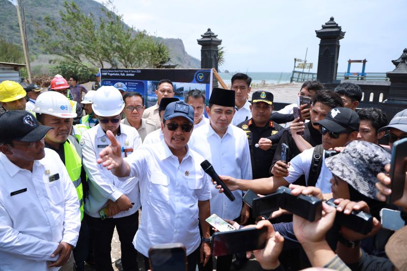 Menteri Kelautan dan Perikanan berbicara kepada wartawan di lokasi pembangunan Kampung Nelayan Merah Putih di Jember, dikelilingi pekerja dan pejabat