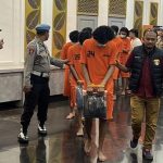 Para tersangka berpakaian tahanan dikawal petugas