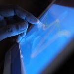 Tangan mengoperasikan tablet layar sentuh