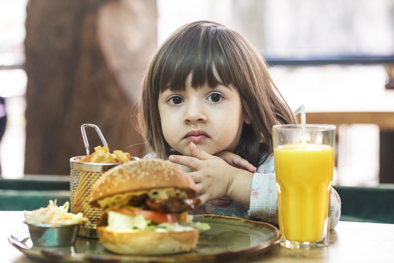 Ilustrasi anak mengonsumsi makanan ultra-proses