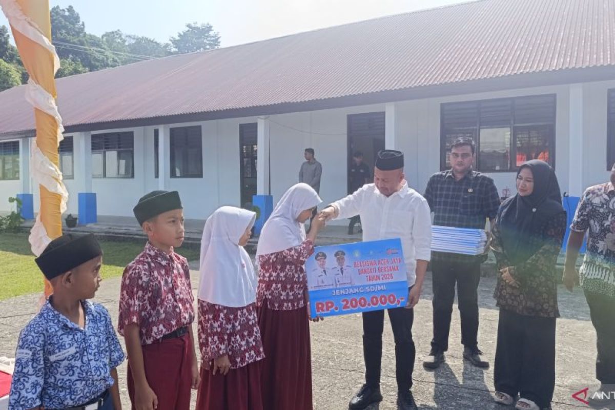 Bupati Aceh Jaya Safwandi menyerahkan bantuan beasiswa kepada pelajar di SMPN 1 Setia Bakti, Aceh Jaya. Foto: ANTARA/Arif