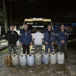 Petugas Sat Reskrim Polres Abdya bersama terduga pelaku di depan dump truck dan jerigen berisi solar subsidi yang diamankan pada malam hari