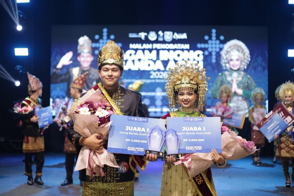 Agam Riffad Syabil dan Inong Meutya Azzahra memegang papan Juara I pada malam penobatan Agam Inong Banda Aceh 2026 di atas panggung