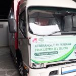 Truk listrik putih dengan spanduk keberangkatan perdana truk listrik PT Sewu Segar Nusantara, berlogo JBL dan Sunpride