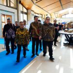 Sejumlah pejabat berbatik berjalan di atas karpet biru di aula sebuah gedung pertemuan