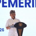 Gubernur Bali Wayan Koster berkemeja putih dan berdestar berbicara di podium dalam forum