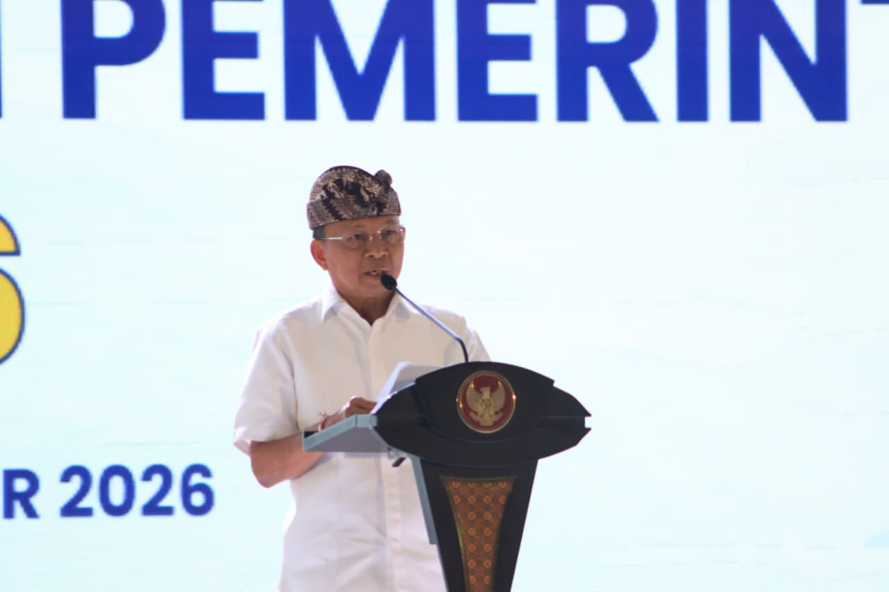 Gubernur Bali Wayan Koster berkemeja putih dan berdestar berbicara di podium dalam forum