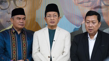Tiga pria berdiri berdampingan, pria di tengah memakai jas putih dan peci hitam