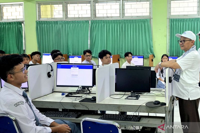 Menteri Pendidikan Dasar dan Menengah meninjau peserta TKA yang mengerjakan ujian di depan komputer di ruang kelas