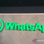 Logo WhatsApp berwarna hijau terang pada papan nama
