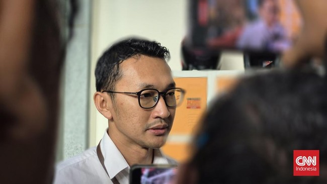 Juru Bicara KPK Budi Prasetyo berkacamata dan berbaju putih di antara kerumunan wartawan