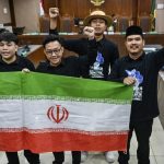 Empat terdakwa di ruang sidang pengadilan mengacungkan kepalan tangan