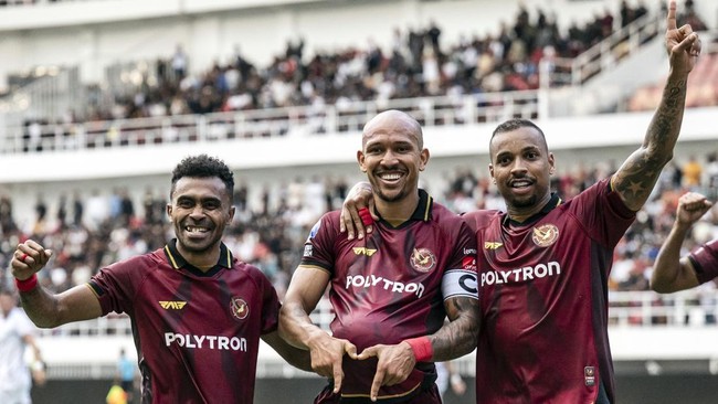 Pemain Java United merayakan gol di stadion dengan penonton di belakang