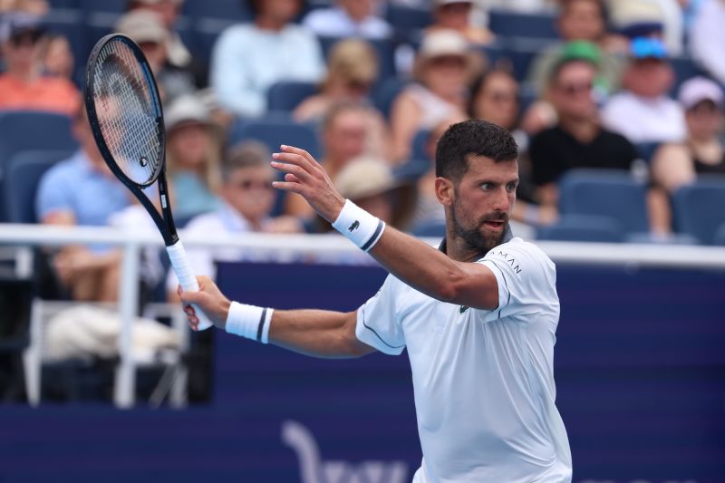 Novak Djokovic memegang raket tenis di lapangan