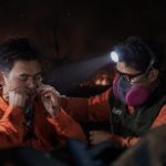 Relawan memadamkan titik api di lahan yang terbakar pada malam hari