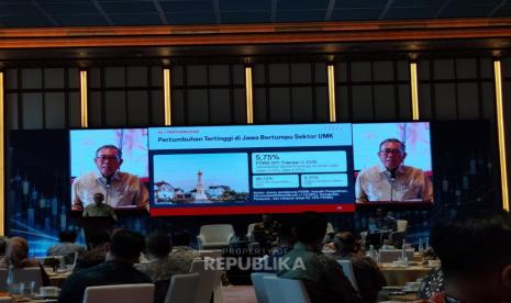 Suasana forum economic outlook dengan layar presentasi pertumbuhan ekonomi dan sektor UMKM