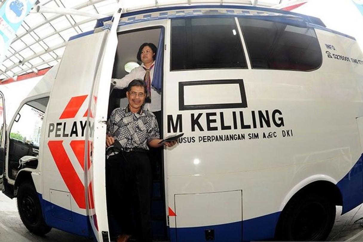 Bus layanan SIM Keliling dengan warga yang baru mengurus perpanjangan SIM