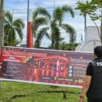 Personel Polres Aceh Jaya memasang spanduk imbauan penertiban BBM subsidi di SPBU