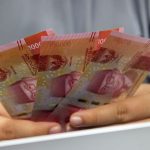 Seseorang memegang beberapa lembar uang rupiah