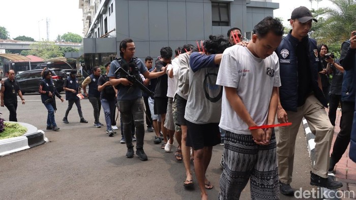 Petugas mengawal sejumlah orang yang ditangkap terkait tawuran maut di Kebon Jeruk, Jakarta Barat