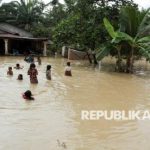 Anak-anak bermain di genangan banjir