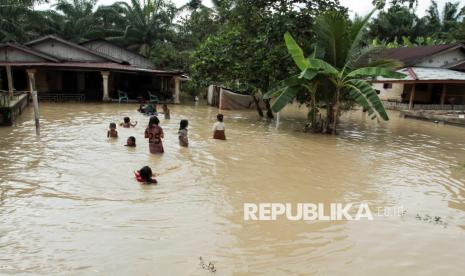 Anak-anak bermain di genangan banjir