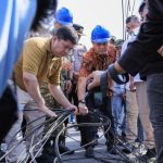 Pekerja menata kabel fiber optik di ruas jalan Kota Pekanbaru