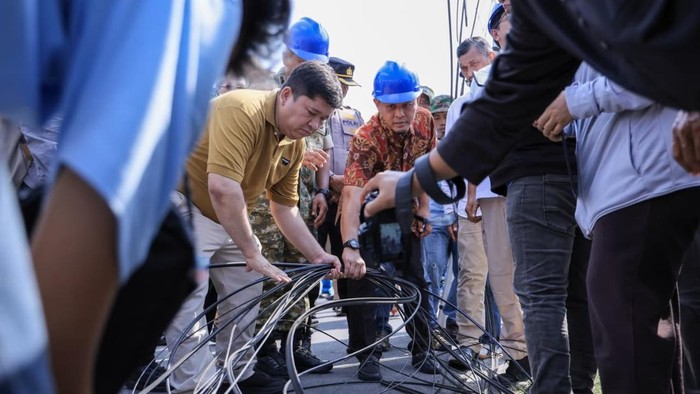 Pekerja menata kabel fiber optik di ruas jalan Kota Pekanbaru