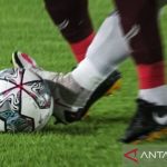 Pemain sepak bola muda Indonesia bertanding di lapangan hijau