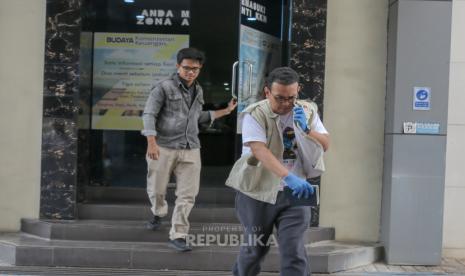 Penyidik KPK berjalan keluar dari kantor Bea dan Cukai sambil membawa koper barang bukti