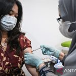 Tenaga kesehatan memberikan vaksinasi kepada seorang warga