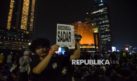 Massa aksi berkumpul di kawasan Bundaran Hotel Indonesia Jakarta pada malam hari