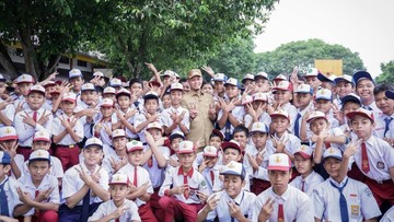 Siswa sekolah dasar dan menengah pertama memakai seragam sekolah