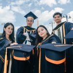 Wisudawan merayakan kelulusan di luar ruangan