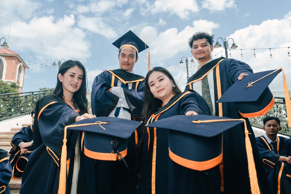 Wisudawan merayakan kelulusan di luar ruangan