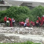 Warga dan petugas membersihkan sampah di aliran sungai