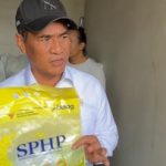 Menteri Pertanian Amran Sulaiman berbicara dalam sebuah acara, dengan latar spanduk kegiatan pertanian