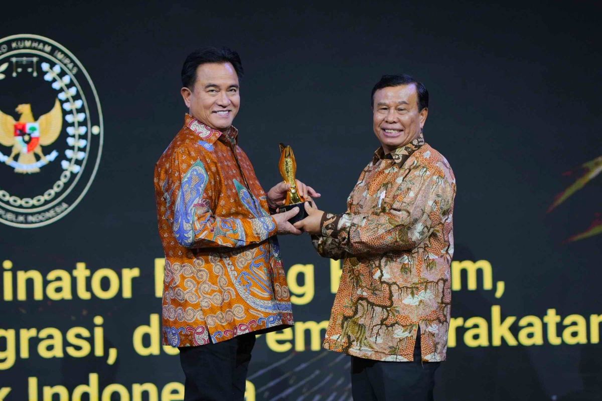 Menko Kumham Imipas Yusril Ihza Mahendra menerima penghargaan di atas panggung