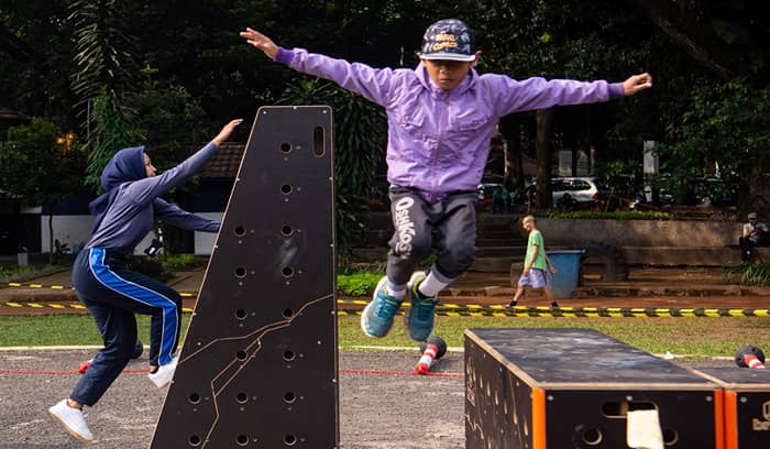 Penggemar parkour melompati rintangan di lapangan olahraga