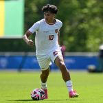 Pesepak bola berlatih di lapangan hijau stadion