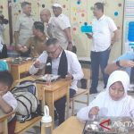 Murid sekolah dasar menyantap makanan program Makanan Bergizi Gratis