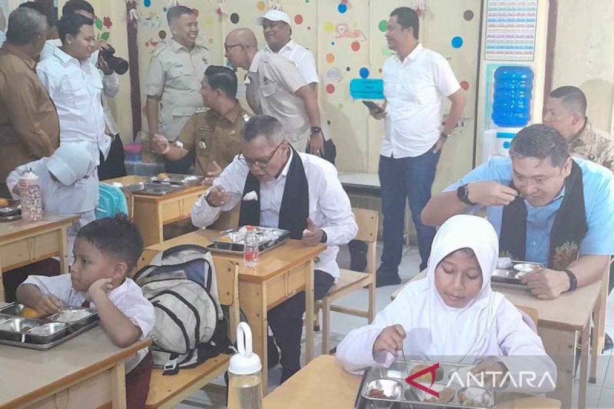 Murid sekolah dasar menyantap makanan program Makanan Bergizi Gratis