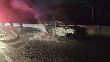 Minibus yang terbakar di ruas Tol Jagorawi Km 33 arah Bogor dengan petugas pemadam di lokasi
