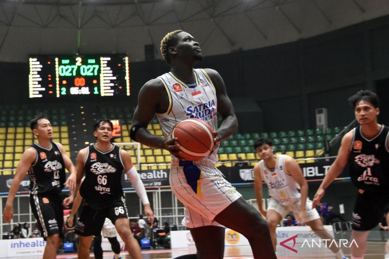 Pebasket Satria Muda berusaha memasukkan bola ke keranjang Rans Simba Bogor