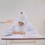 Seorang siswa Muslim menulis saat belajar di dalam kelas di Indonesia