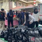 Warga mengantre di pasar murah untuk membeli paket sembako bersubsidi